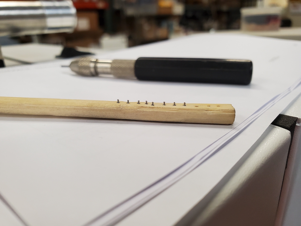 Bamboo chopstick with shallow holes holds the screws in place for micro abrasive processing